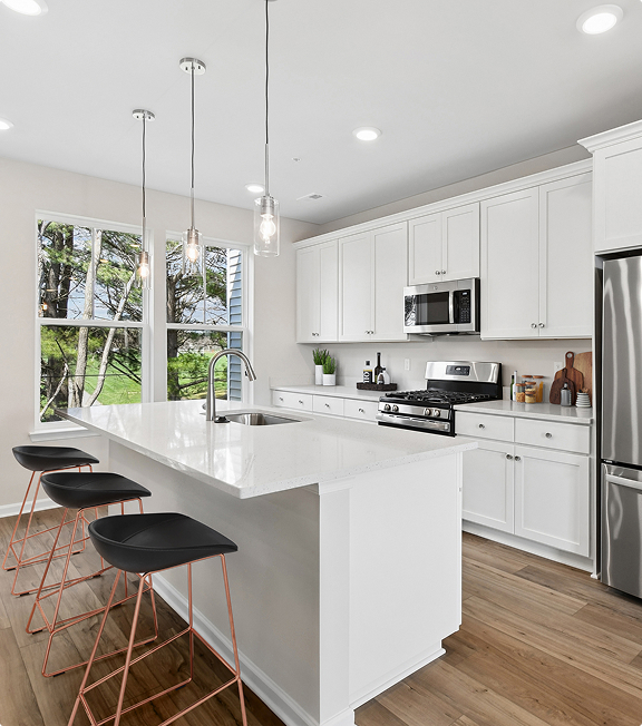 Kitchen with white cabinetry and pendant lighting